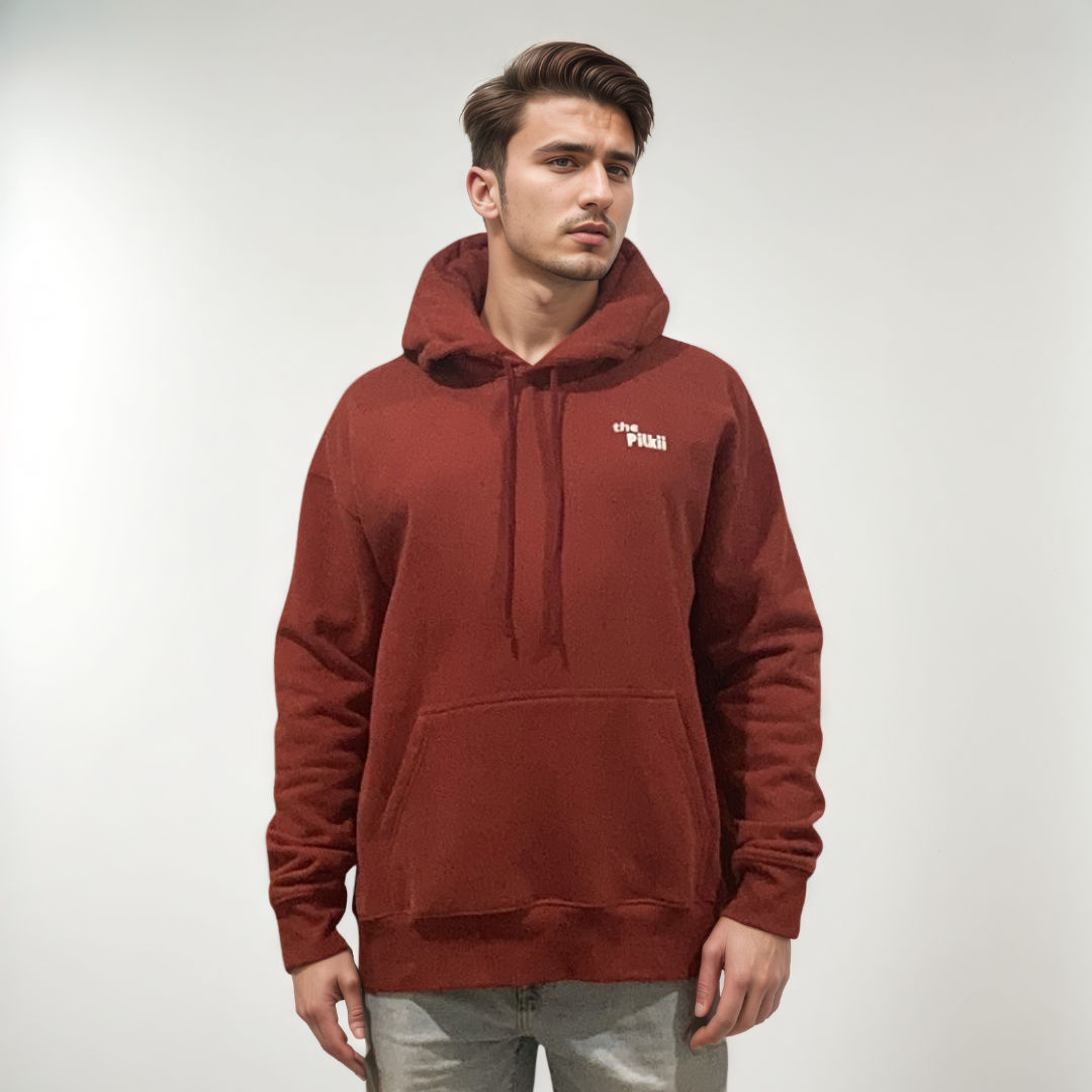 Man wearing a red hoodie with a logo on a plain background