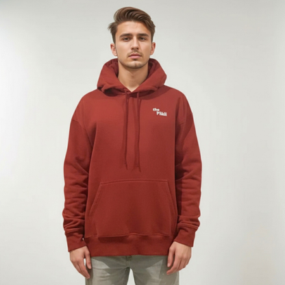 Man wearing a red hoodie with a logo on a plain background